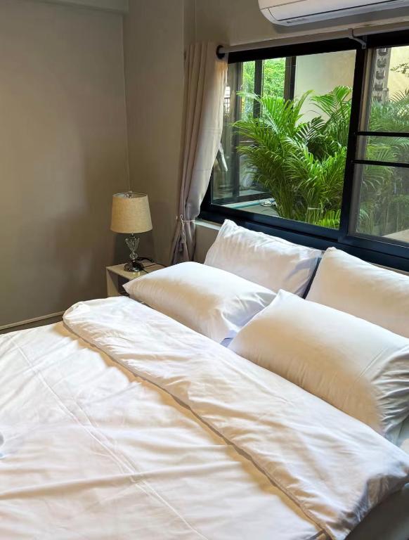 two beds with white pillows in a room with a window at Pridi cozy home with good location Type B in Bangkok