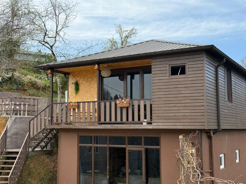 a house with a balcony on top of it at Stillwood Tsikhisdziri in Kobuleti