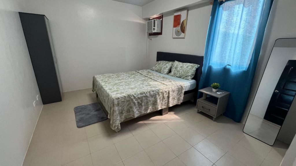 a small bedroom with a bed and a mirror at Plumera Mactan Square in Mactan Island