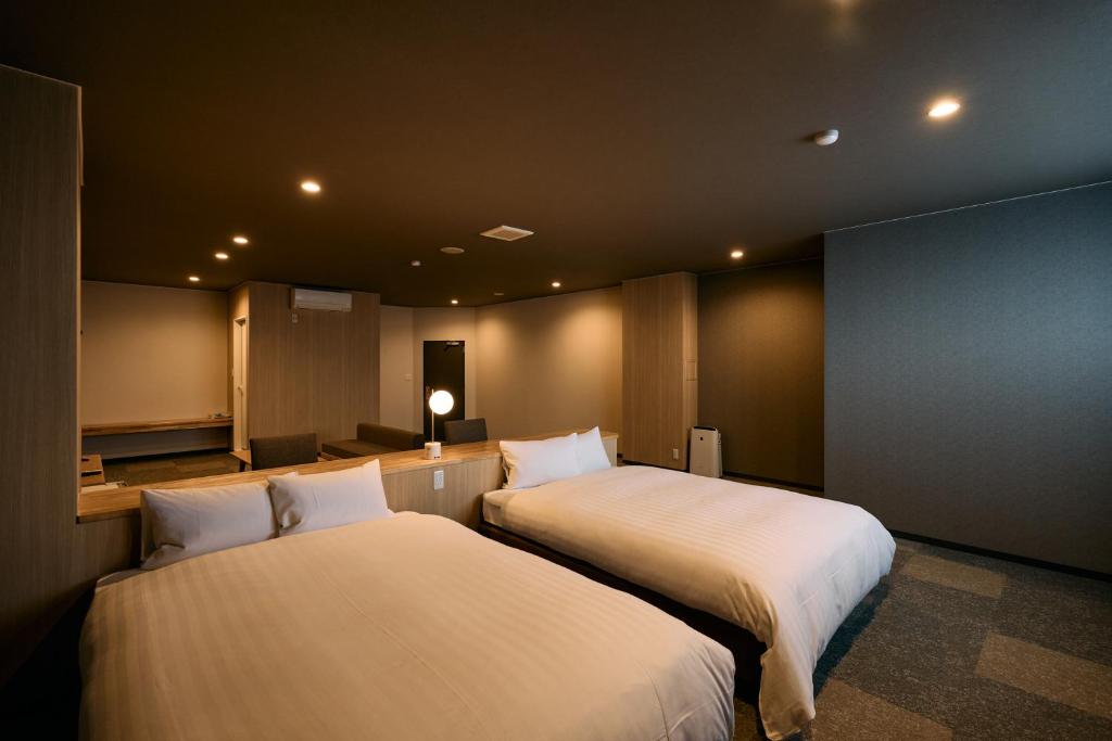 a room with two beds in a room at COZY HOTEL NUKUI shimanami in Imabari