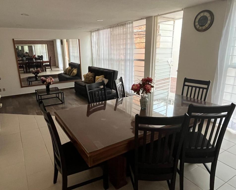 a dining room and living room with a table and chairs at Rey 179 in Morelia