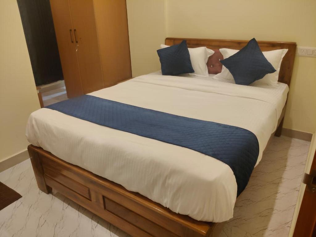 a bedroom with a large bed with blue pillows at Royal Inn in Mysore