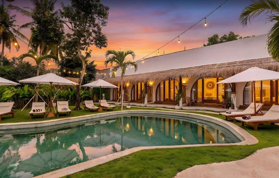 a villa with a swimming pool and a resort at Roh Villas Kuta Lombok in Kuta Lombok