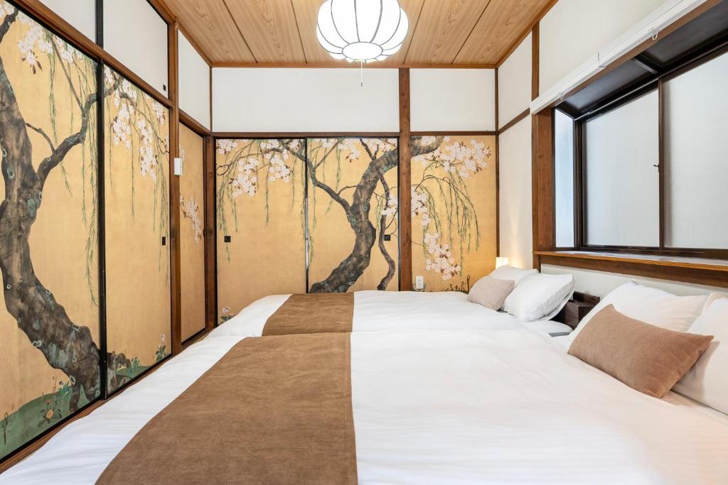 a bedroom with a bed with a painting on the wall at Tsubaki in Otsu