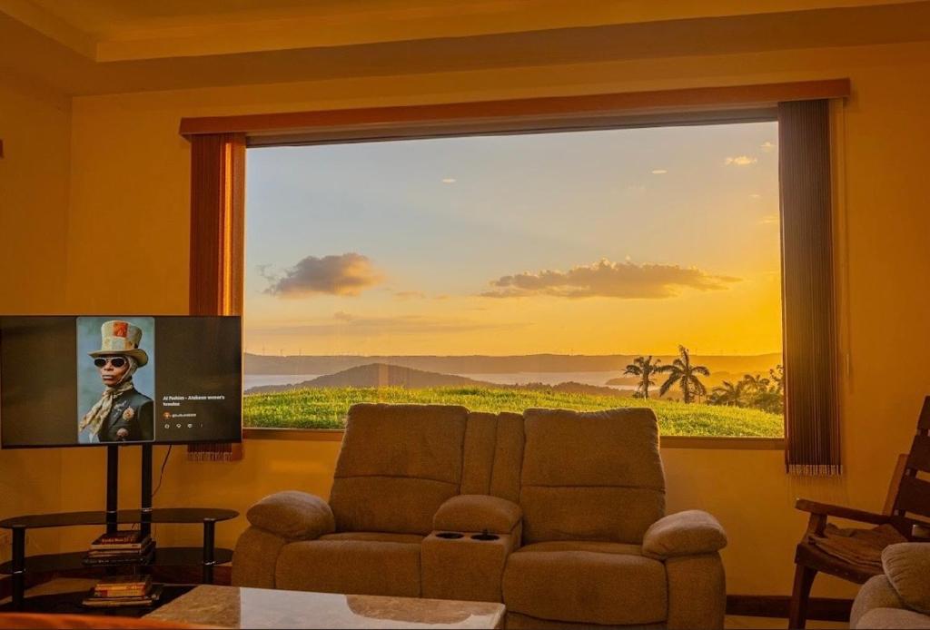 a living room with a large window and a couch at Loma Linda in Arenal