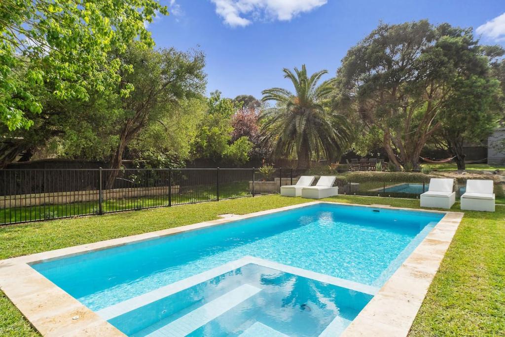 a swimming pool in the yard of a house at Villa Syrene Pool and Spa Retreat in Rye