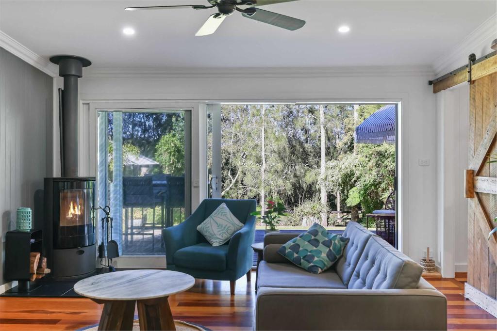 a living room with a couch and two chairs at The Shack - Myola in Myola