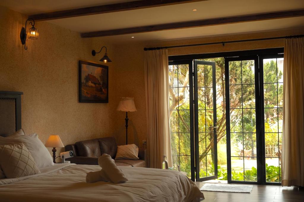 a bedroom with a bed and a sliding glass door at SIA Home in Da Lat