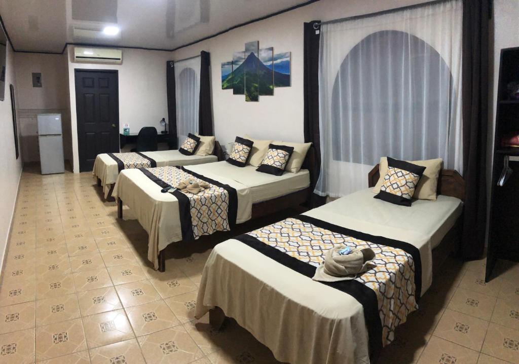 a group of four beds in a room at HOTEL DEL RiO in Liberia