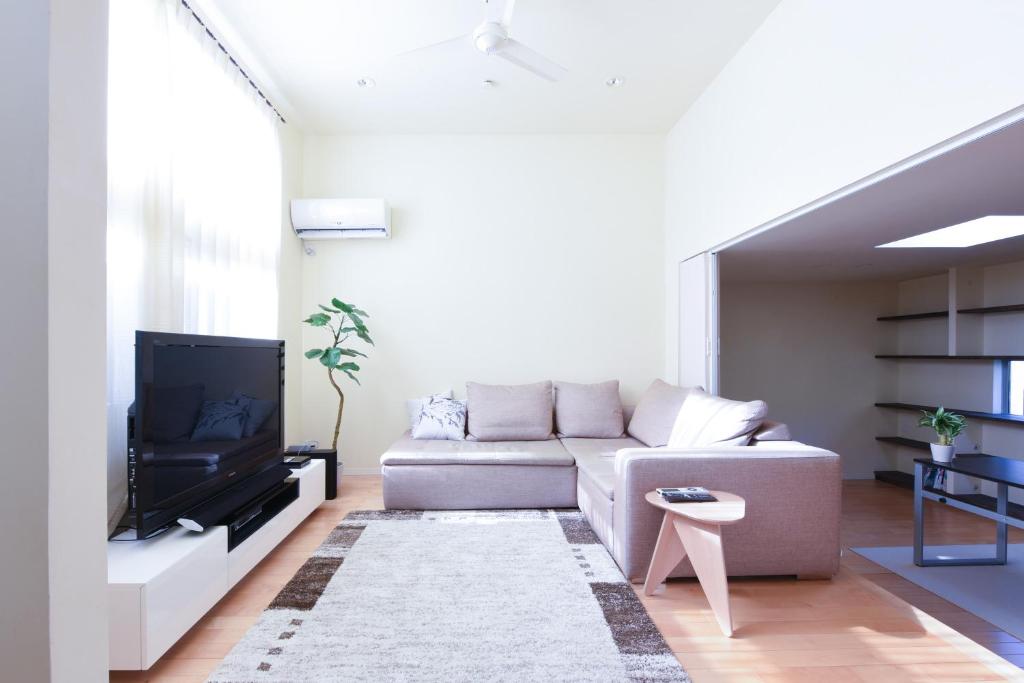 a living room with a couch and a tv at Luxury New House in Tokyo