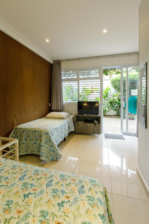 a hotel room with two beds and a television at K1 RESIDENCE Campinas in Campinas