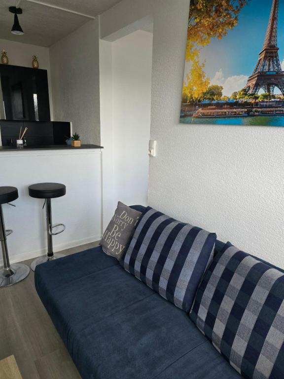 a bed in a room with a picture of the eiffel tower at Le Stud in Belfort