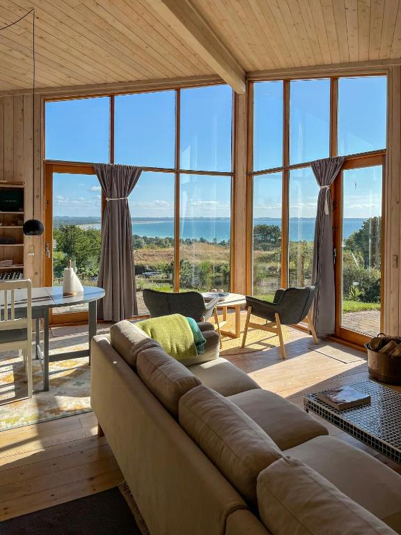 a living room with a couch and large windows at Architect's House With Panoramic View In Lumsås in Lumsås