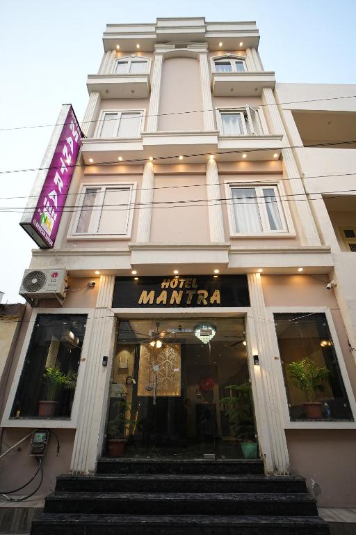 a white building with stairs in front of it at Hotel Mantra Inn in Haridwār