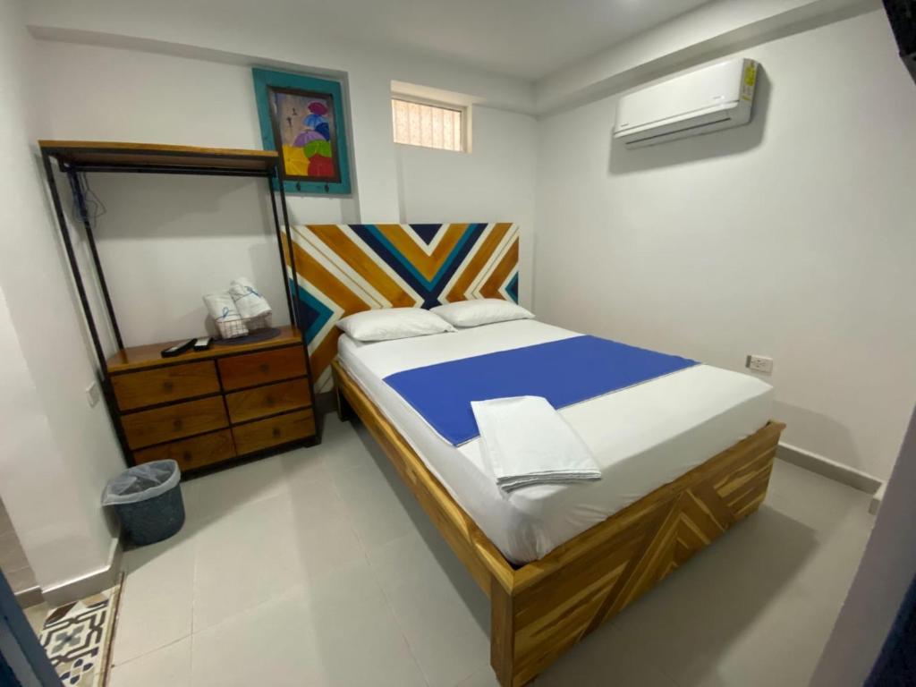 a small bedroom with a bed and a mirror at Hostal Nomadas in Santa Marta