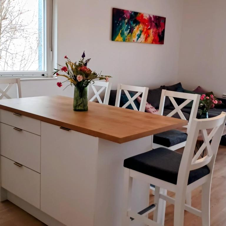 a kitchen with a table and chairs with a vase of flowers at Apartman Sarah in Kastel Novi