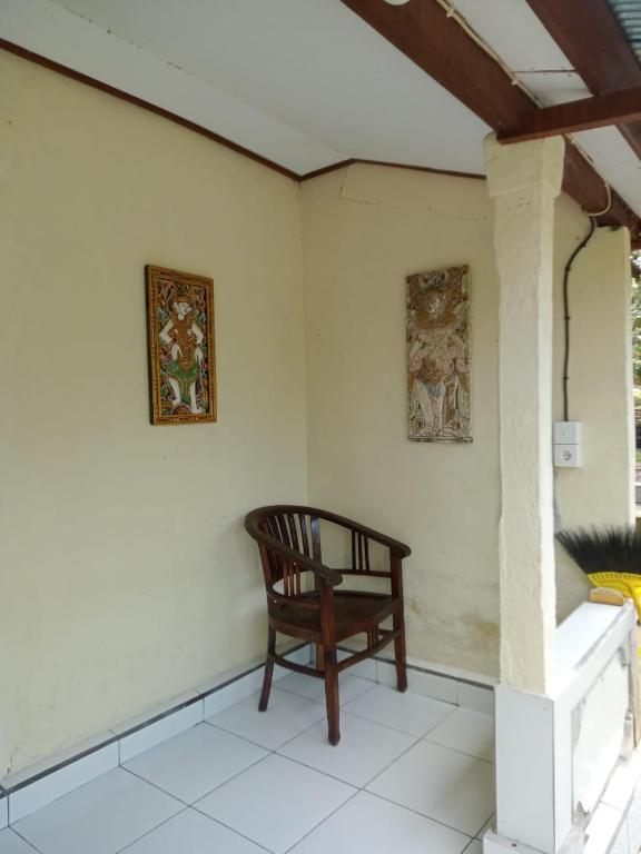 a room with a chair and two pictures on the wall at pondok tegal jero in Jatiluwih