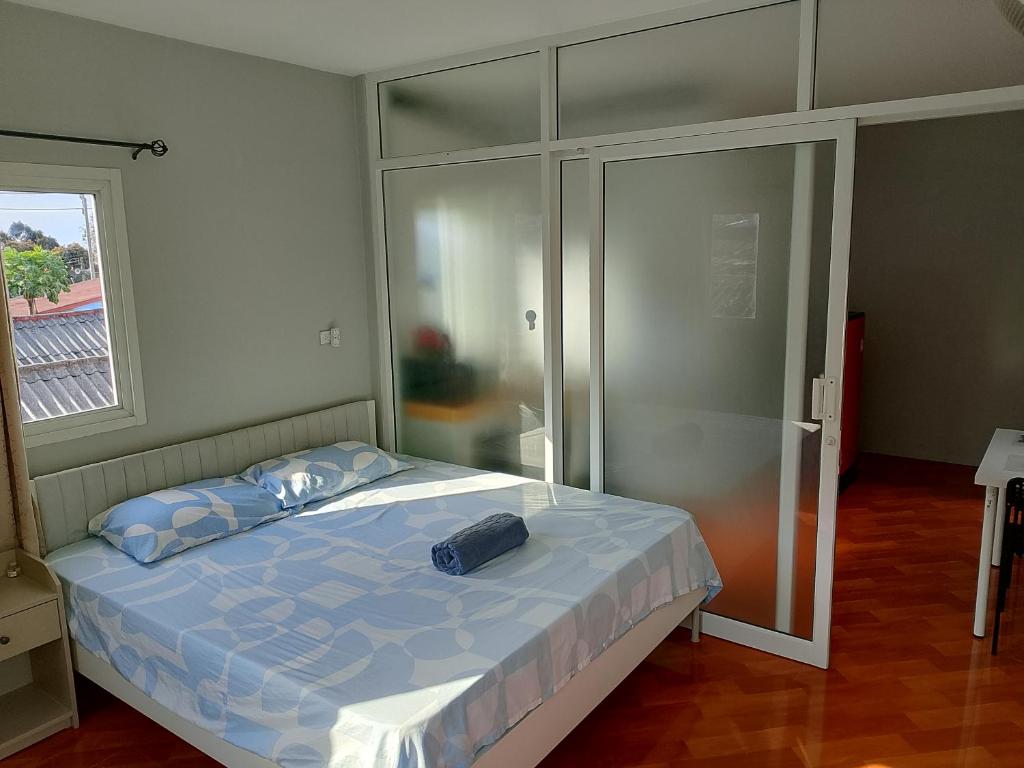 a bedroom with a bed and a glass closet at Mango Guest House Choeng Thale in Ban Thalat Choeng Thale