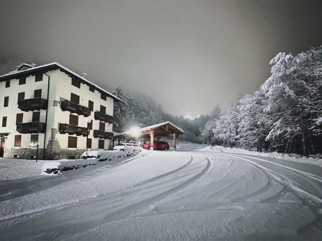 a snow covered road with a building in the background at Cervinia House - Alpine Apartments & Chalet in Valtournenche
