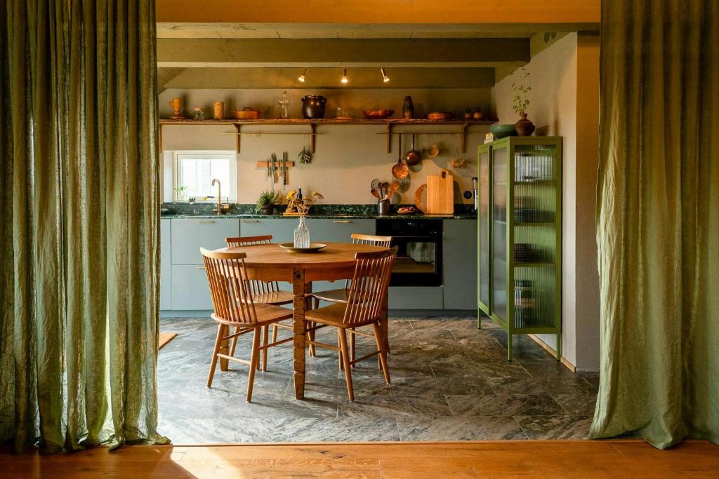 a dining room with a table and chairs in a kitchen at Restored House With Art In Österlen in Borrby