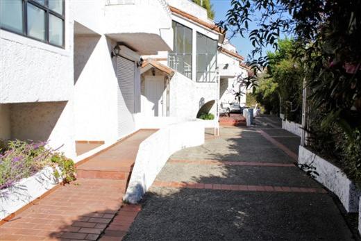 a street with a white building and a building with a staircase at Amplia casa en Reñaca para 10 personas in Viña del Mar