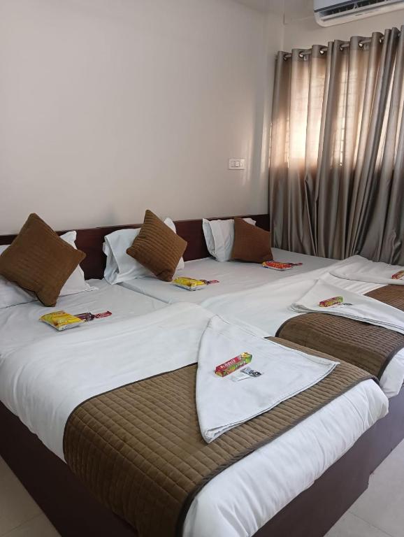 two beds in a hotel room with towels on them at Hotel Maharaja Path in Ujjain
