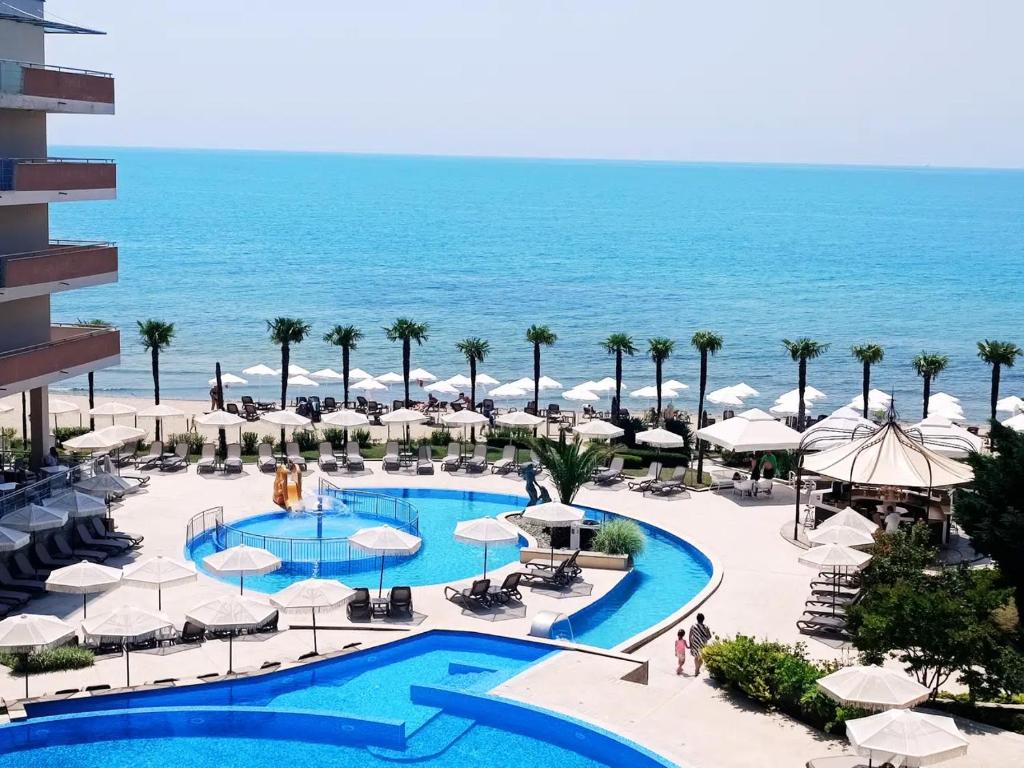 a view of the pool at the resort with the ocean in the background at Sandy Bay Resort - All Inclusive Private Beach Hotel in Sveti Vlas