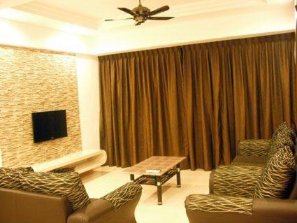uma sala de estar com dois sofás e uma televisão em Lacy's Crown Imperial Court Apartment em Cameron Highlands