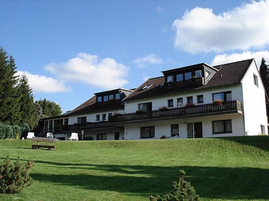 a large white building on a grassy field at Haus Panorama Sankt Andreasberg in Sankt Andreasberg