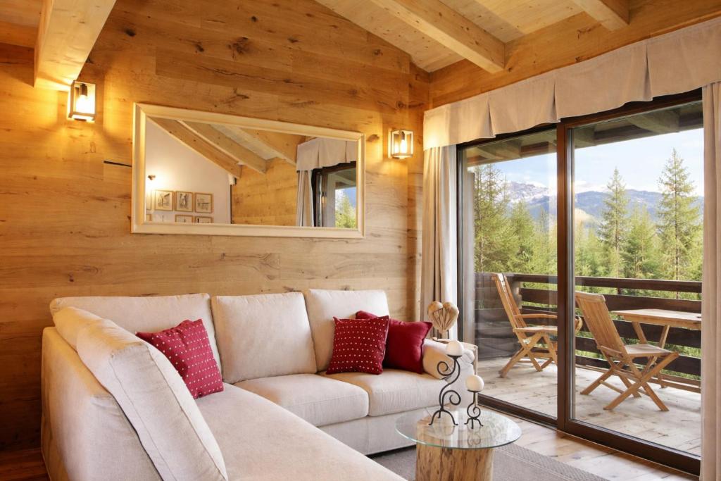 a living room with a couch and a mirror at SKYWAY LOFT - Residence Veronza con piscina, Dolomiti Affitti in Cavalese