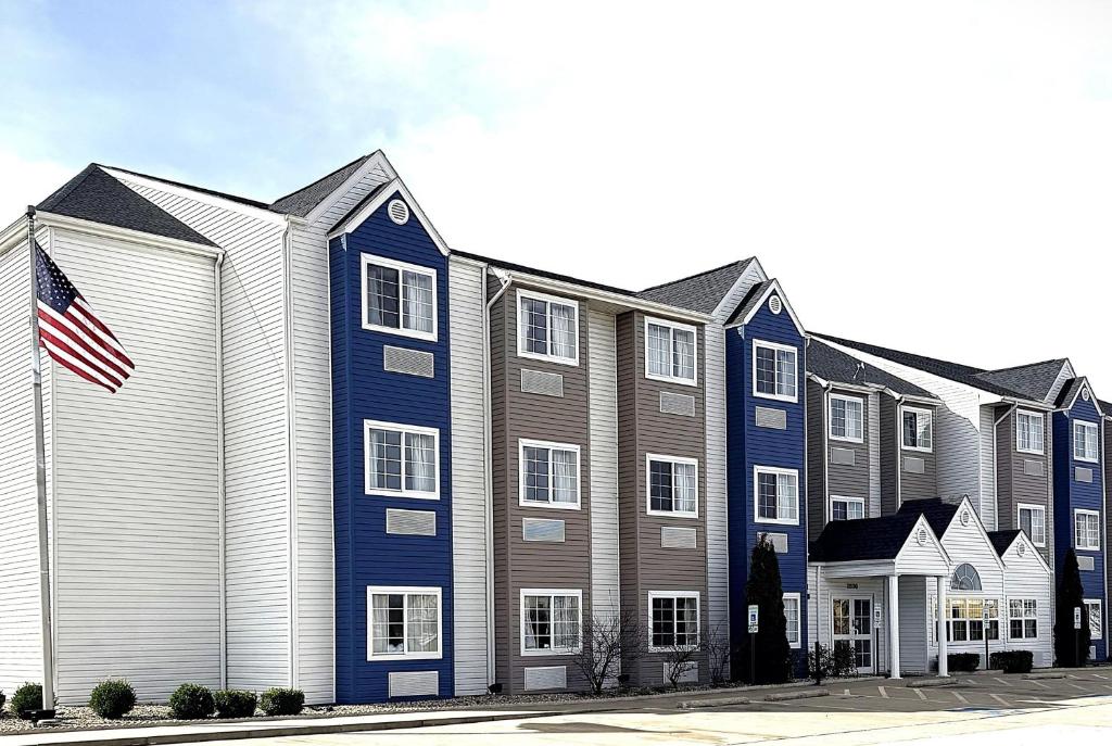 a large building with an american flag in front of it at Microtel Inn & Suites by Wyndham Springfield in Springfield
