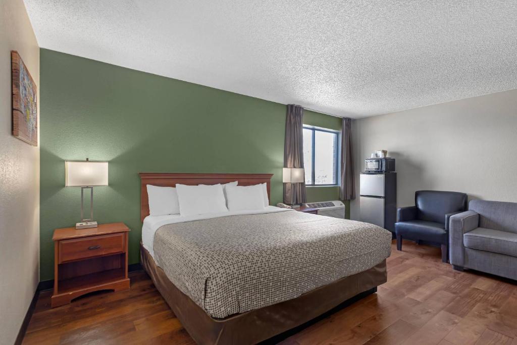 a bedroom with a bed and a blue chair at Econo Lodge Longmont East in Longmont