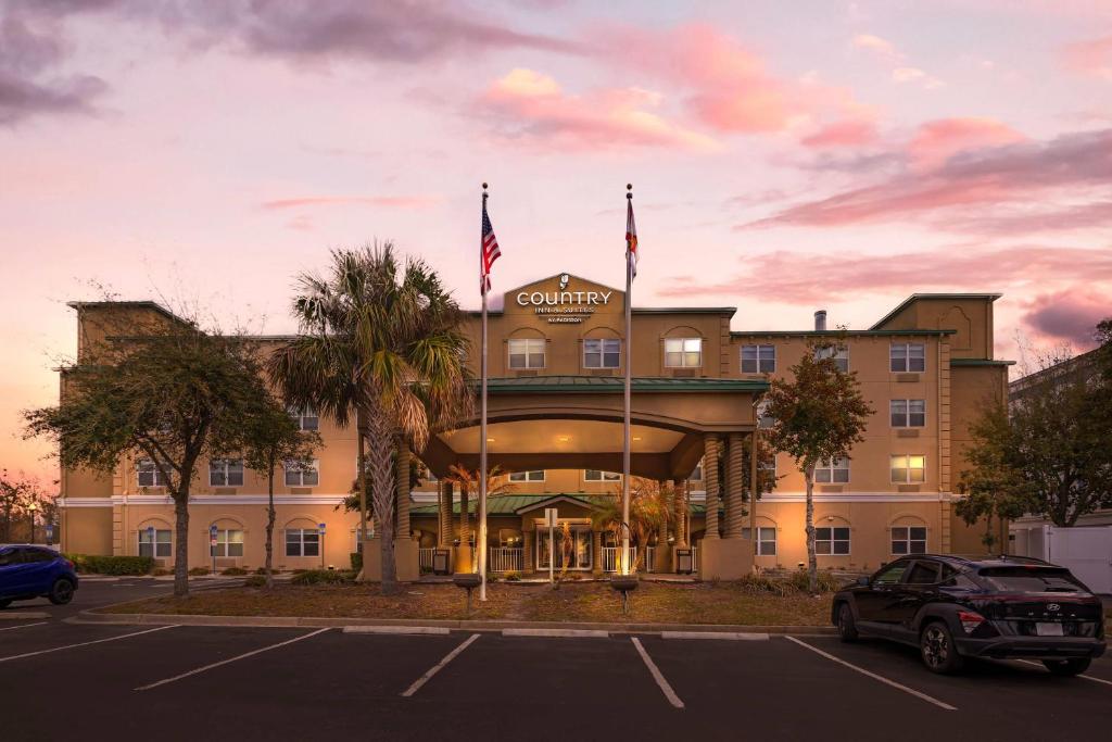 a building with two flags on top of it at Country Inn & Suites by Radisson, Jacksonville West, FL in Jacksonville