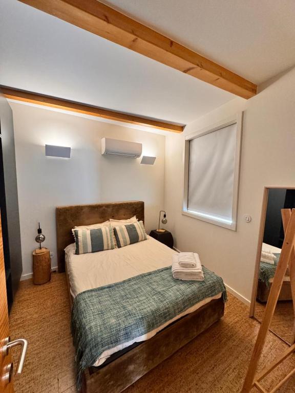 a bedroom with a large bed with a window at Rooftop Teatro Aveiro in Aveiro