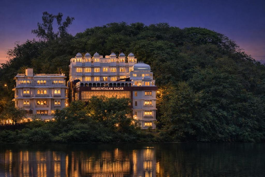 a building with its lights on at night at Shakuntalam Sagar - Luxury Boutique Lake View Hotel, Udaipur in Udaipur