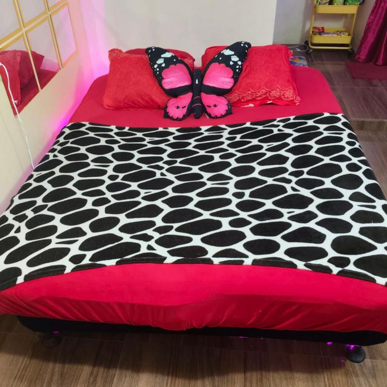 a bed with a black and white comforter and pillows at Ciel's Deluxe Haven in Binangonan