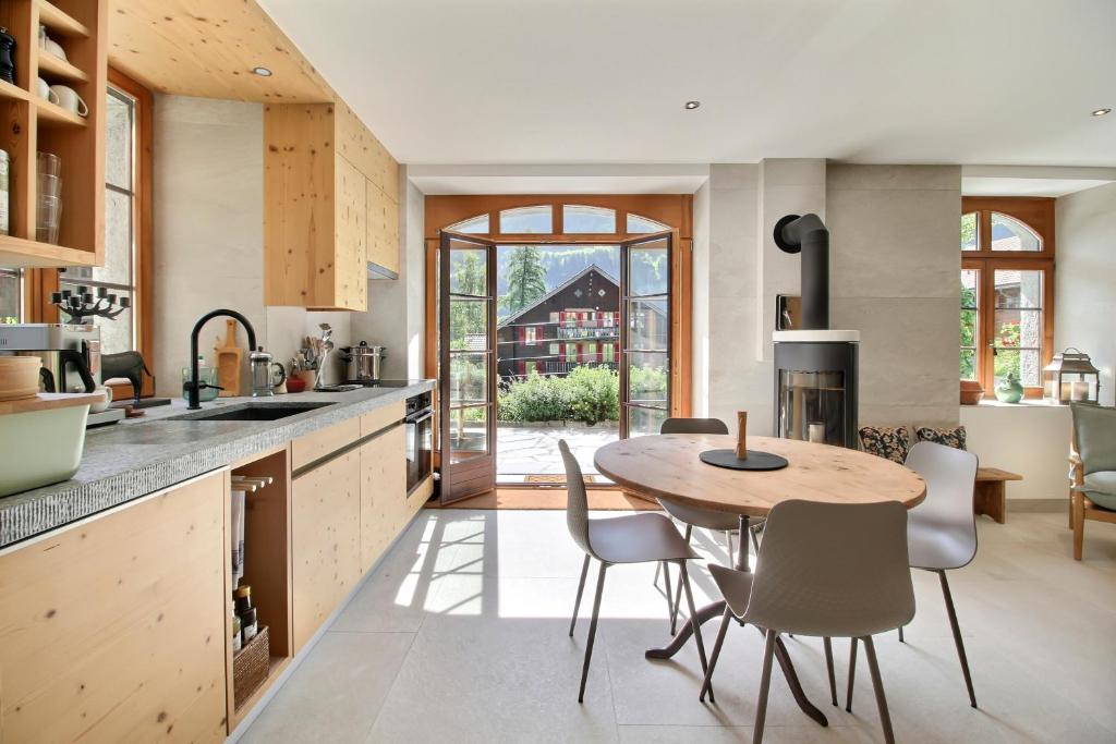 a kitchen and dining room with a table and chairs at Garden Heart of the village Swedish Stove in Champéry