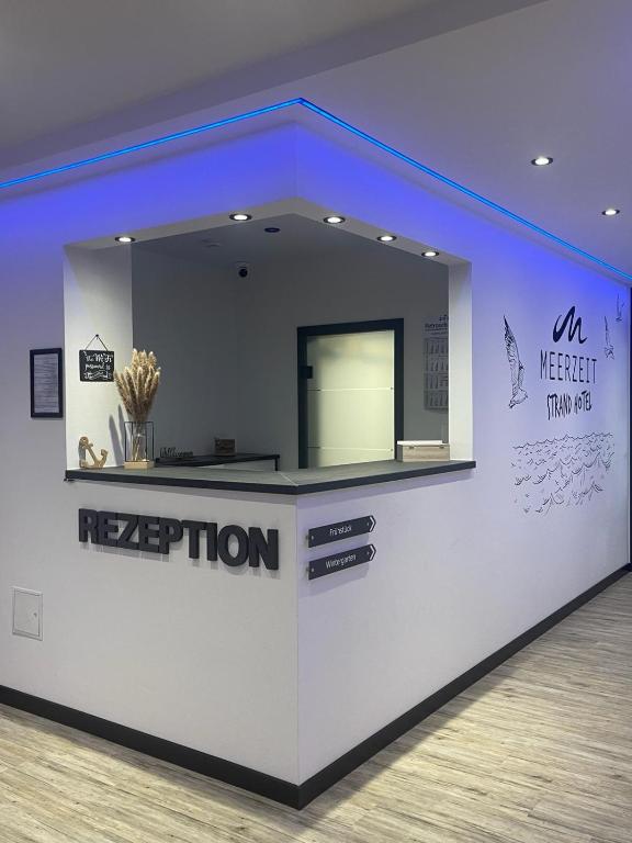 a white counter in a room with a reception at Meerzeit Strandhotel in Neuharlingersiel