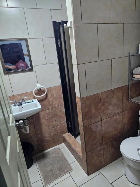 a bathroom with a shower with a sink and a toilet at Apartamento 9 Tec in Cartago