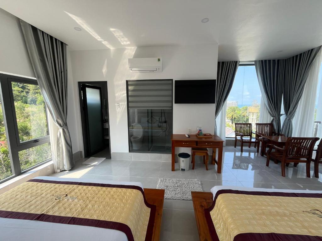 a bedroom with two beds and a table and chairs at Villa caribe phu quoc in Phú Quốc