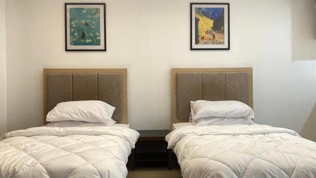 two beds sitting next to each other in a room at UrbaNest WCY in Wakaf Che Yeh