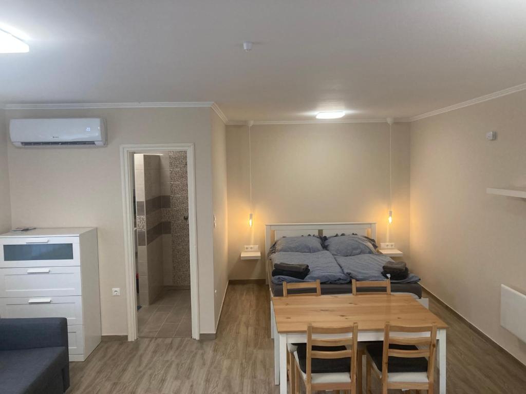 a bedroom with a bed and a table and chairs at Dunaparti Kuckó in Kiskunlacháza