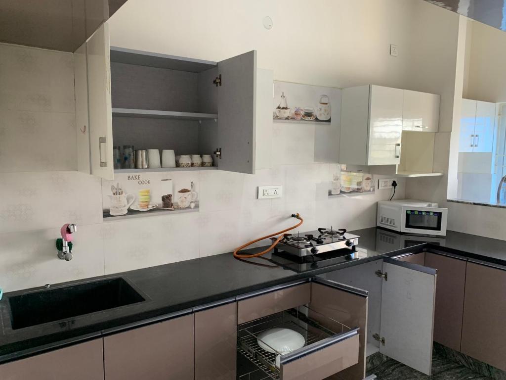 a kitchen with white cabinets and a counter top at XD Hotels 101 in Bangalore