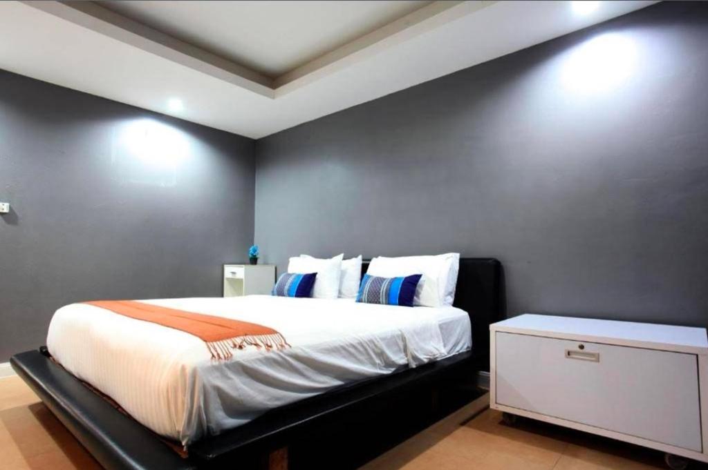 a bedroom with a large bed and a white cabinet at DelMar by Mery World Hospitality in Pattaya South