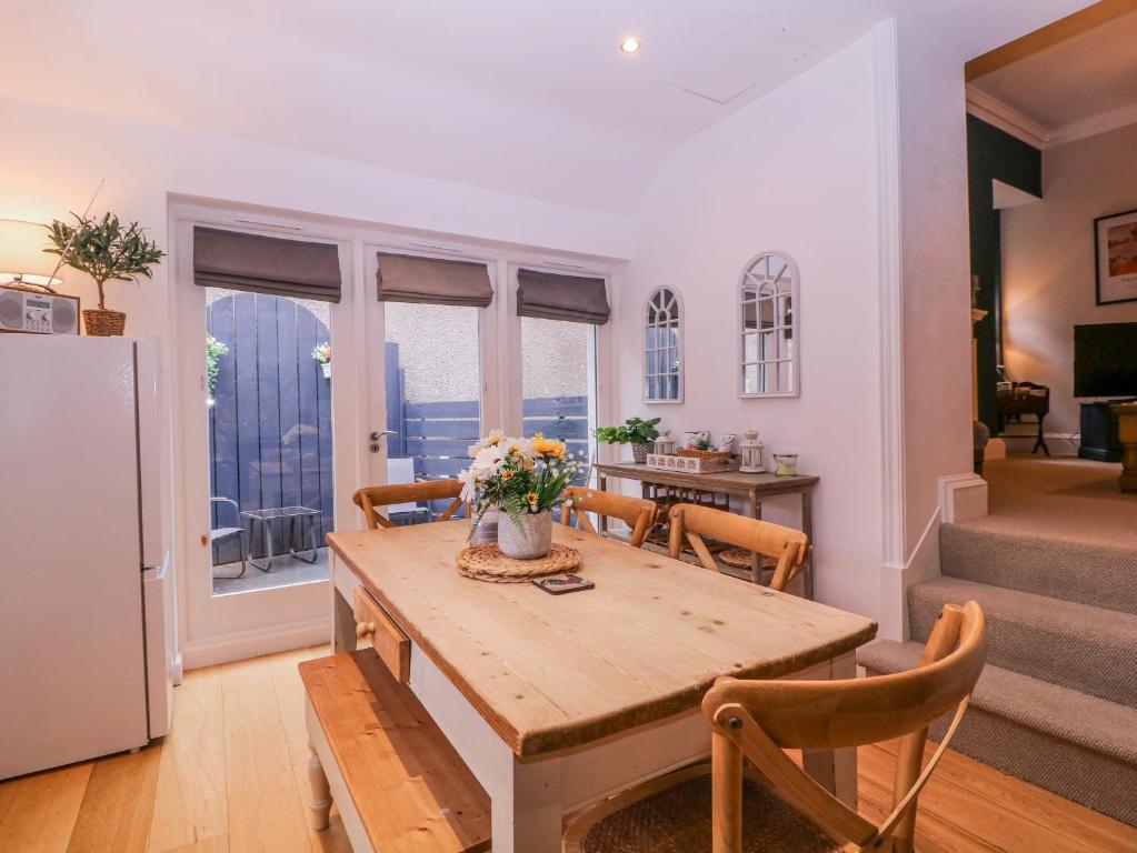 a kitchen and dining room with a table with flowers on it at Stylish Town Apartment in Ross on Wye