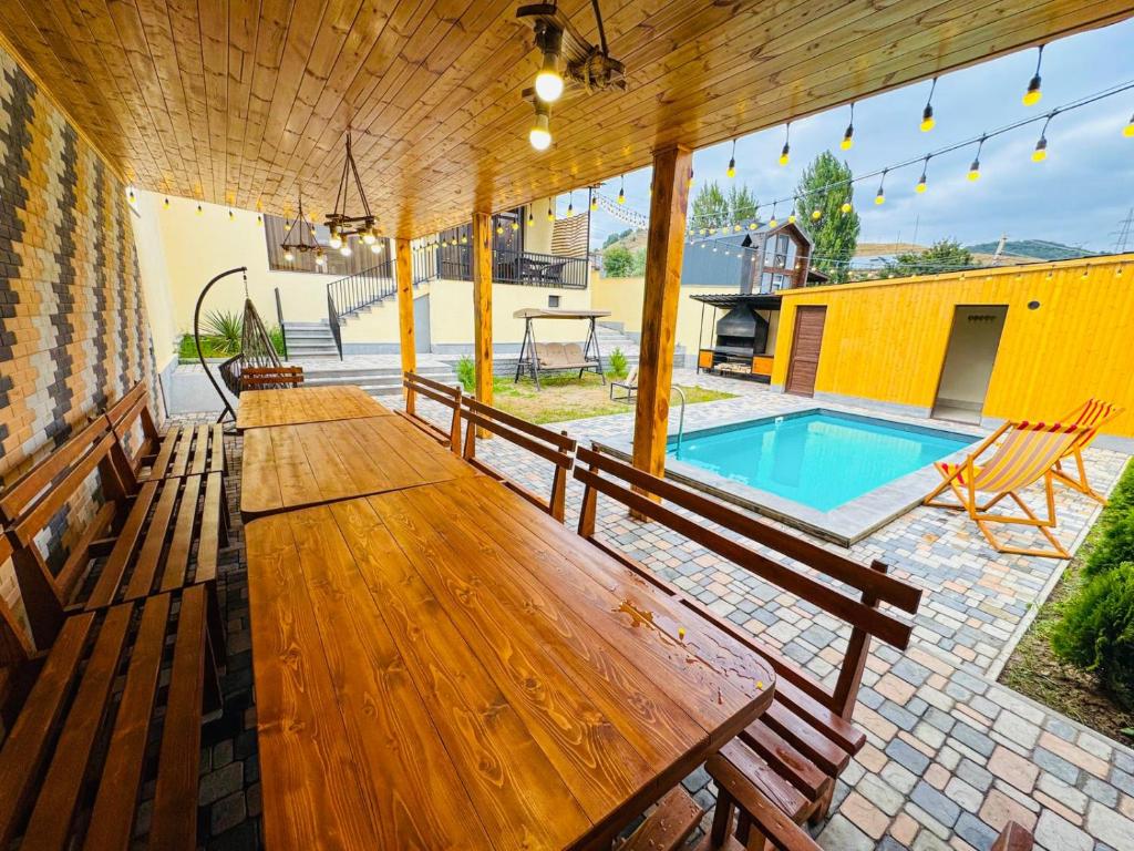 a patio with wooden benches and a swimming pool at Miracle View Dilijan in Dilijan