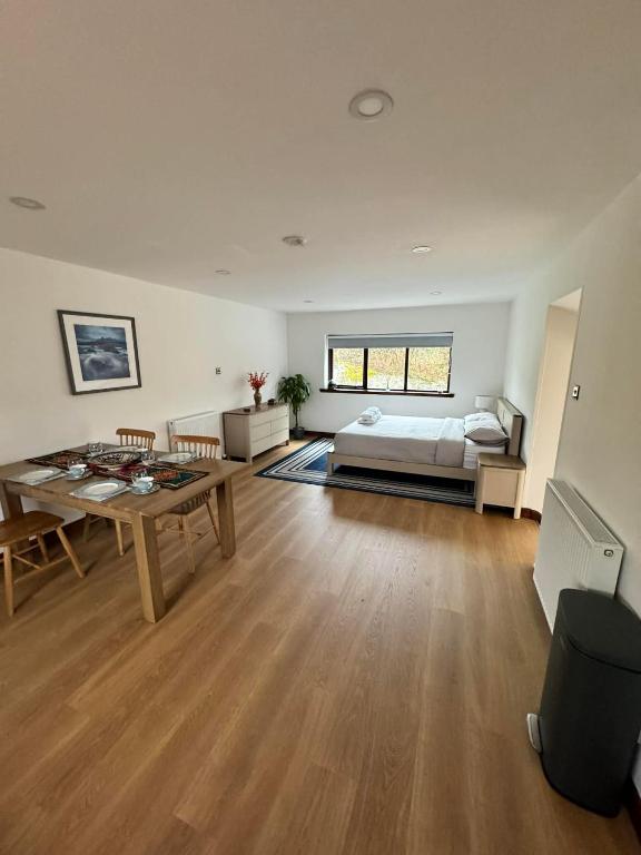a large room with a bed and a table at 1 Manse Lane in Portree