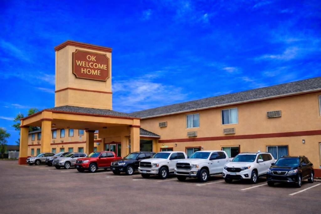 a hotel with cars parked in a parking lot at OK Welcome Home Hotel in Alva