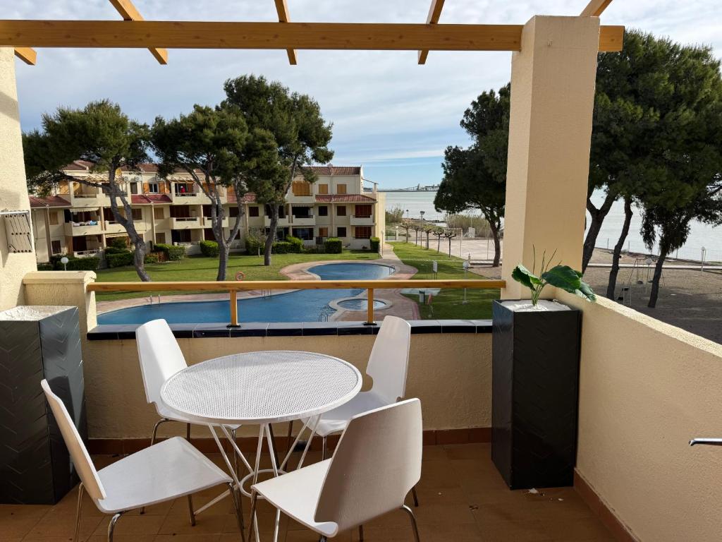 ein Balkon mit Tisch und Stühlen und ein Pool in der Unterkunft Punta Atico in Alcanar
