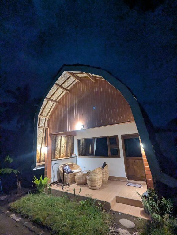 a house with a large arched window and a patio at Jati Rinjani Tetebatu in Tetebatu